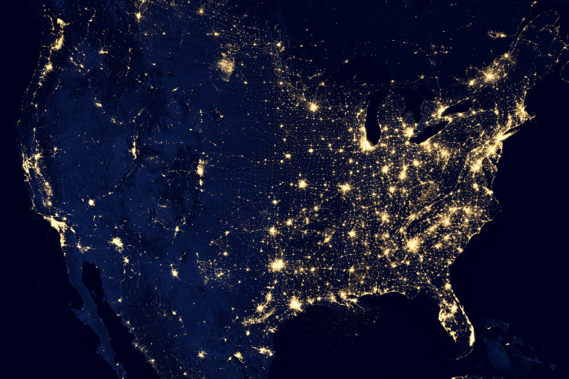 A night view of the continental 48 states with all of the lights on, highlighting the major cities and small towns.